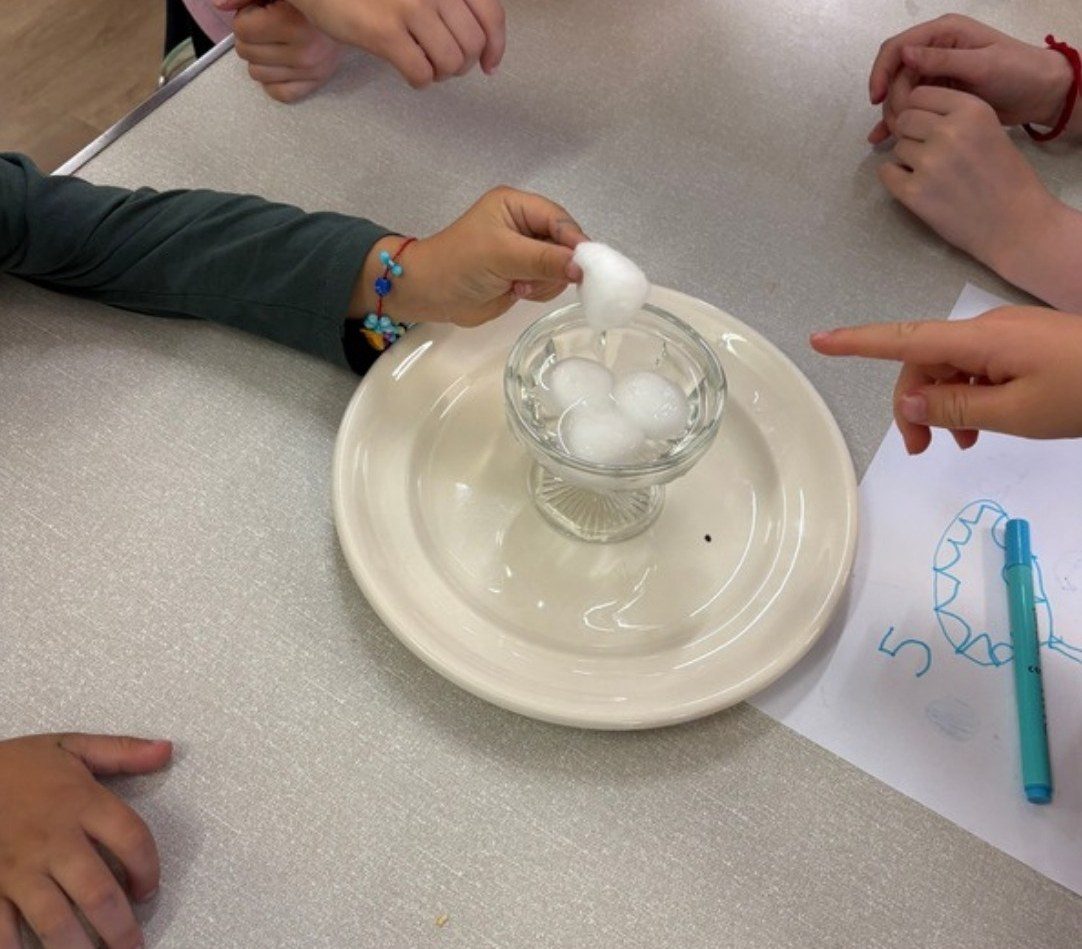 A science experiment with cotton wool and a glass of water