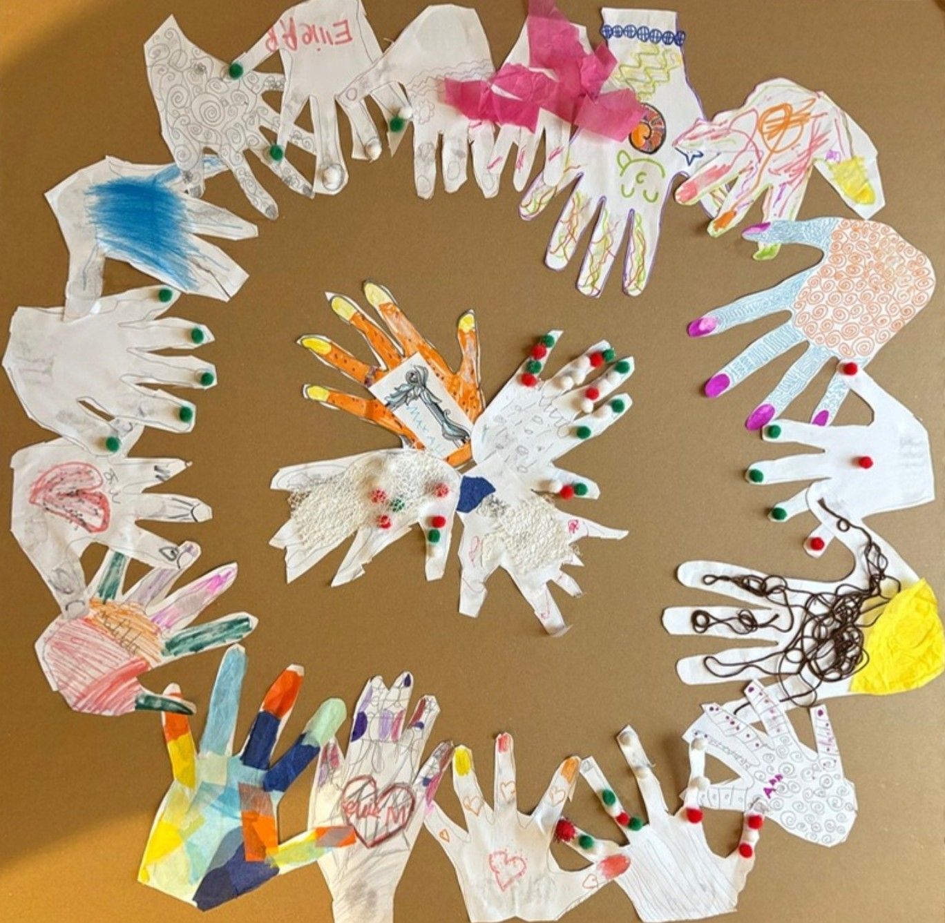 A circle of colourful paper handprints made by the ELF community